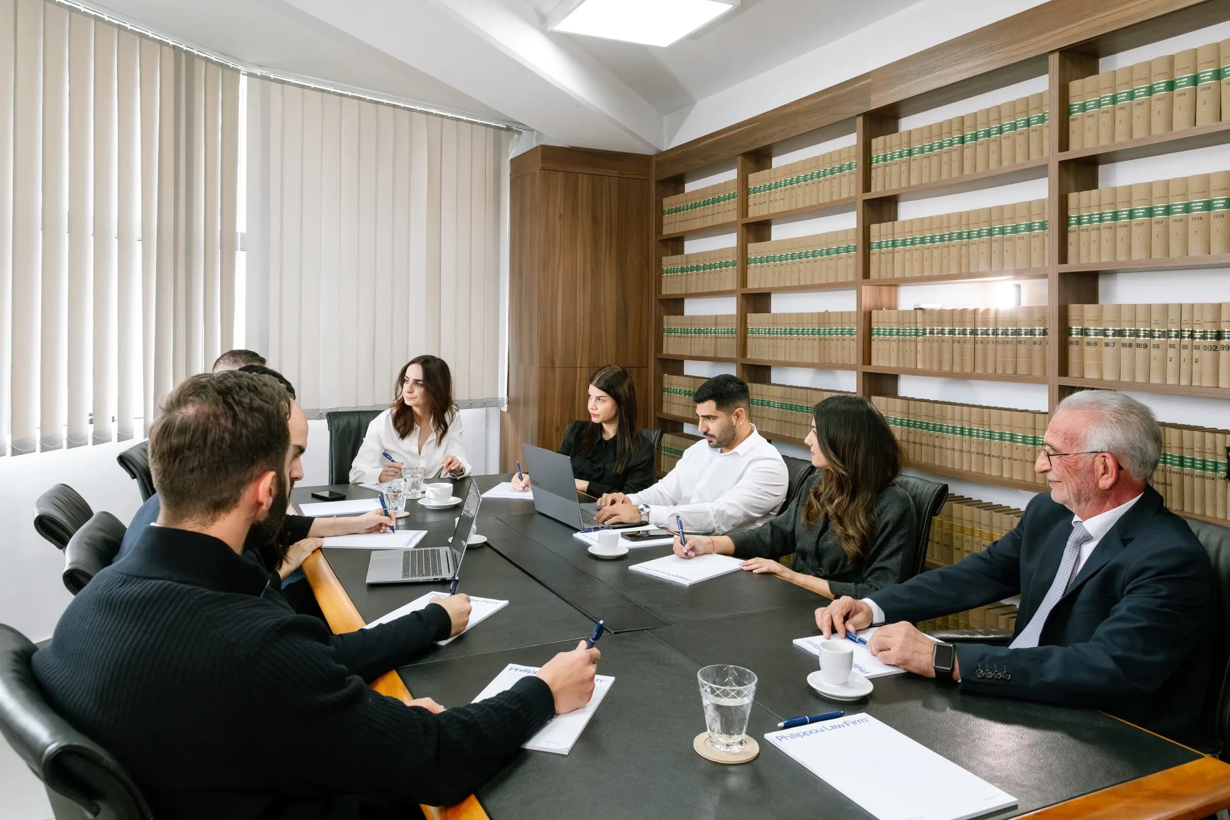 Philippou Law Firm legal team discussion in the law library conference room